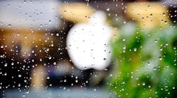An Apple logo viewed through rain-spattered glass. (Image courtesy of Divya Thakur, Flickr).