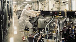 A Micron Technology worker checks semiconductor equipment in a maintenance corridor. (Image courtesy of Micron Technology).