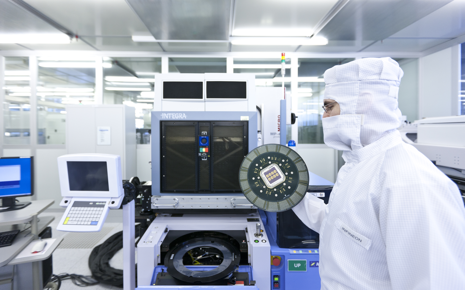 An Infineon Technologies engineer holds a 200 millimeter wafer in a semiconductor cleanroom in Dresden, Germany. (Image courtesy of Infineon).