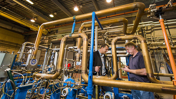 Jim Pasch principal investigator of the SCO2 Brayton Cycle Research and Development Program and Darryn Fleming principal investigator of the SCO2 Brayton Heat Exchange Program investigate a turbine and compressor inside a test facility at Sandia National Laboratories Image courtesy of Randy Montoya and Department of Energy