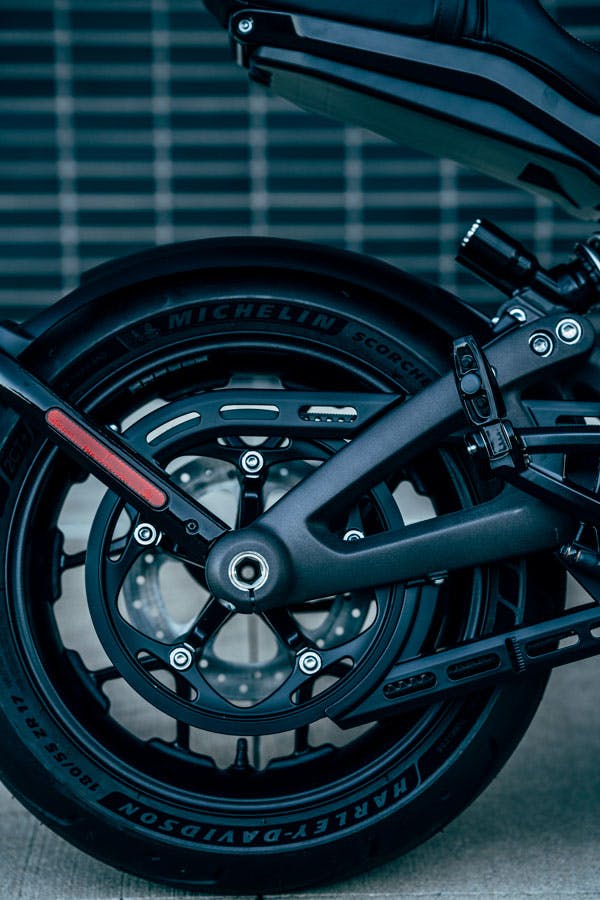 The rear wheel is powered by a belt drive. The rear fender hugs and moves up and down with the wheel so that it almost disappears when the bike is moving. This permits the tail section&rsquo;s high, wasp-like contour below the seat.