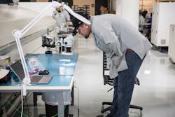 A worker examines a PCB inside of Tempo Automation’s smart factory. A worker examines a PCB inside of Tempo Automation’s smart factory.