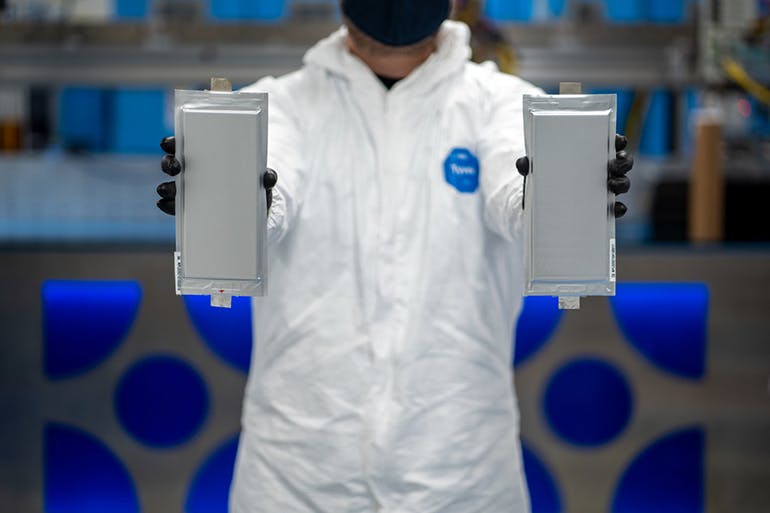 A Solid Power manufacturing engineer holds two 20 ampere-hour (Ah) all-solid-state battery cells for the BMW Group and Ford Motor Company. (Source: Solid Power)