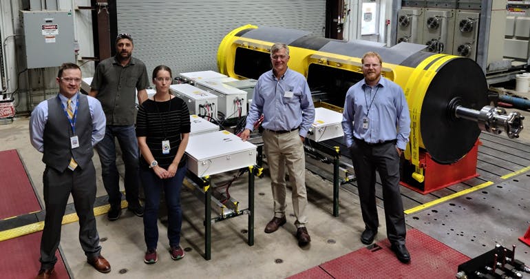 Dan Cahill (DOE), Scott Lambert (NREL), Rebecca Foa (NREL), Reenst Lesemann (CEO, C&centerdot;Power), and Erik Mauer (DOE) are pictured in front of the SeaRAY autonomous offshore power system at NREL&rsquo;s Flatirons Campus. (Photo by Vern Slocum, NREL)