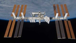 1. This image shows the ISS orbiting Earth while solar arrays capture sunlight for power. (Image: NASA)