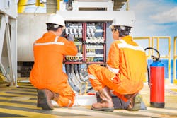 1. Two technicians performing reactive maintenance on a control panel.