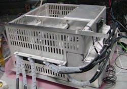 2. Here’s the chassis with the top cover removed. Inside the chassis is a converter and two filament transformers with their secondary sides insulated to 140 kV. (Image courtesy of Reference 3) 2. Here’s the chassis with the top cover removed. Inside the chassis is a converter and two filament transformers with their secondary sides insulated to 140 kV. (Image courtesy of Reference 3)