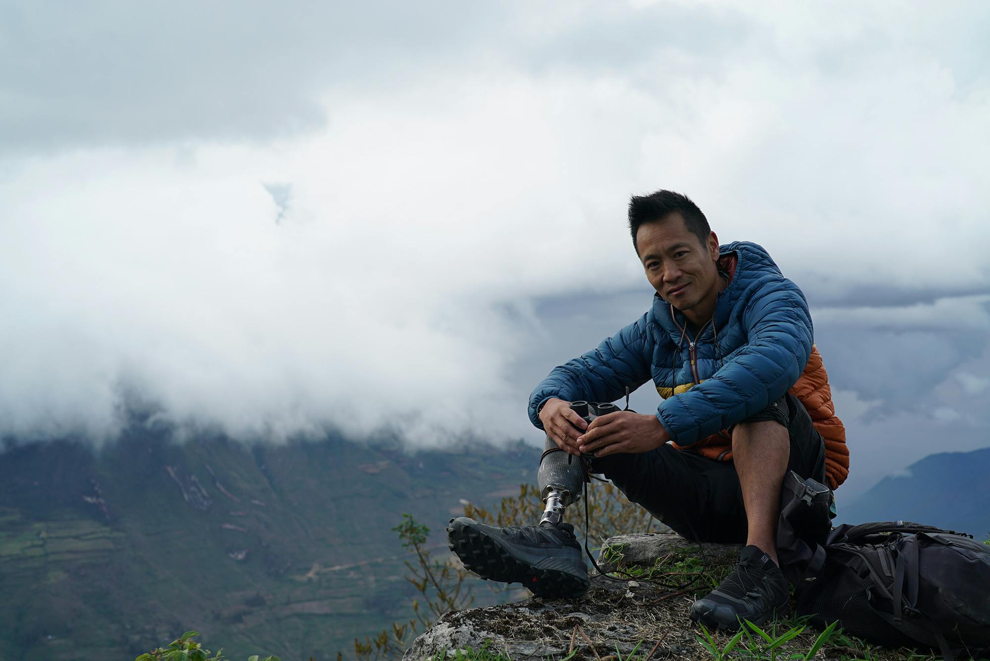 Albert Lin sitting on the edge of a cliff during his quest to find the lost city of the Chachapoyas in Peru.