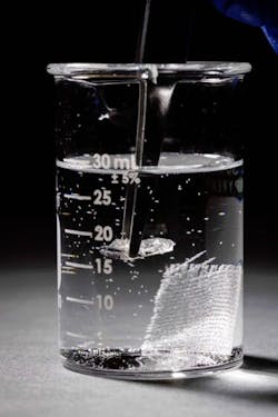 3. Tweezers are used to remove a piece of vitrimer from the solvent. The sheet of reinforcing glass fibers sits in the background. 3. Tweezers are used to remove a piece of vitrimer from the solvent. The sheet of reinforcing glass fibers sits in the background.