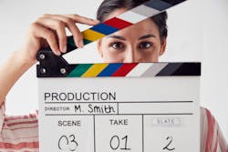 Portrait Of Female Videographer Holding Clapper Board On Video Film Production In White Studio Portrait Of Female Videographer Holding Clapper Board On Video Film Production In White Studio