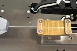 Test fixture used to demonstrate that a fiber made from a common polymer material can handle heat differently as it’s stretched