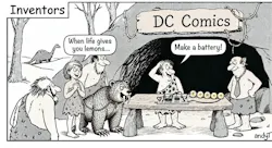 Black-and-white “Inventors” cartoon set outside a Stone Age cave labeled “DC Comics.” A caveman stands behind a stone table with a crude battery made of sliced lemons wired together and connected to a small electronic circuit board. Nearby, a cavewoman says, “When life gives you lemons…” He says, “Make a battery!” Other cavemen, a large saber-toothed animal on a leash, and a modern-looking manager in a shirt and tie watch; a dinosaur is in the background.